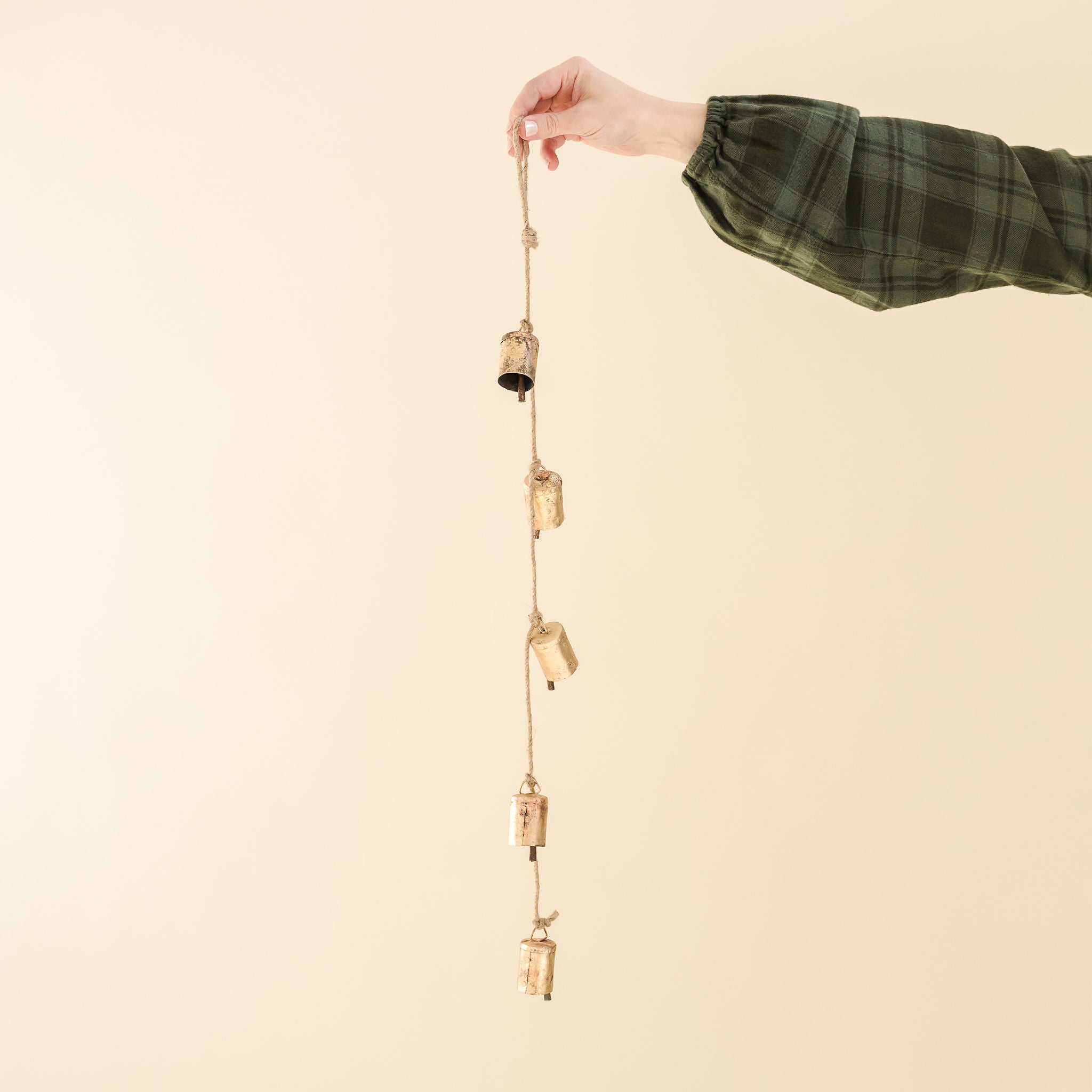 a garland of five gold bells on a natural twine string