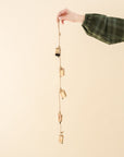 a garland of five gold bells on a natural twine string