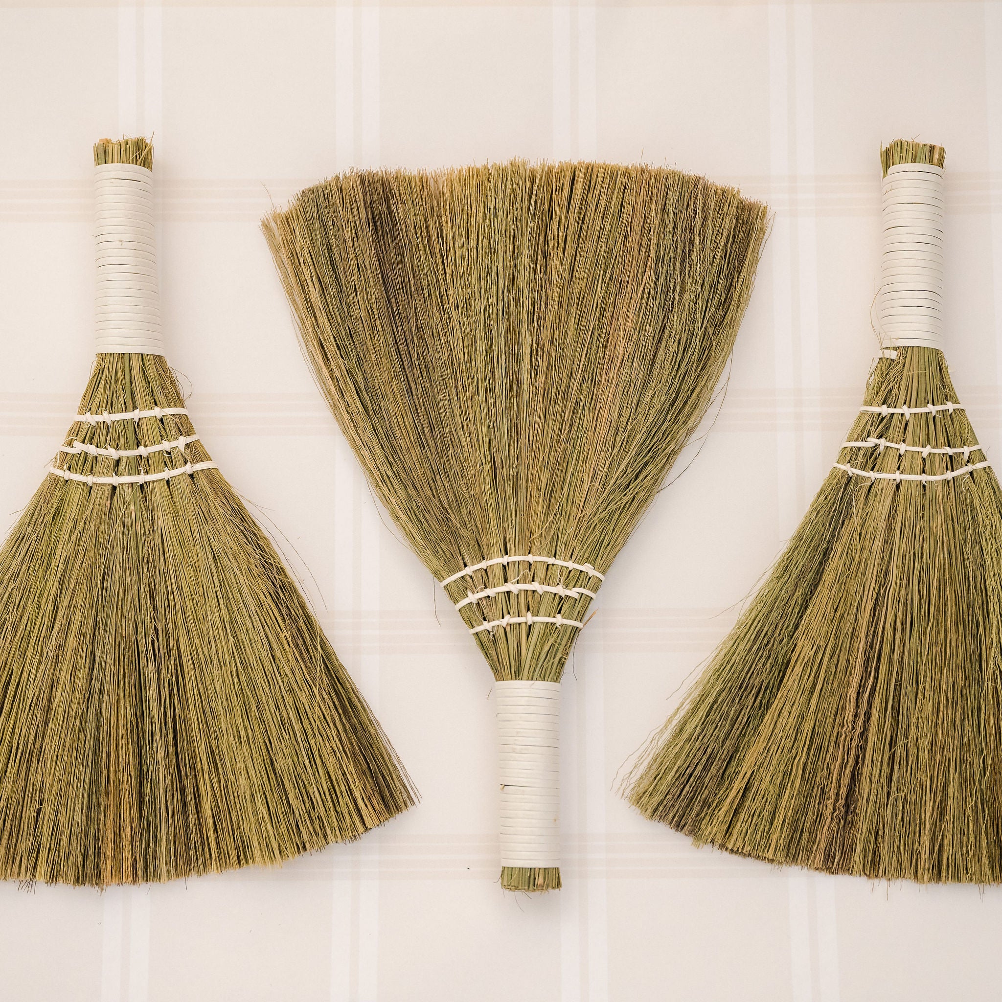 three brooms laid on backdrop