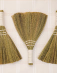 three brooms laid on backdrop